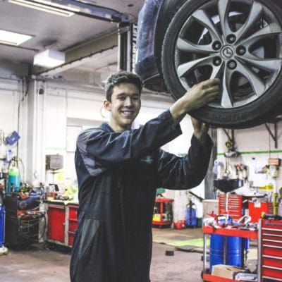 Motor Vehicle student Reiss Blackman working on a car wheel
