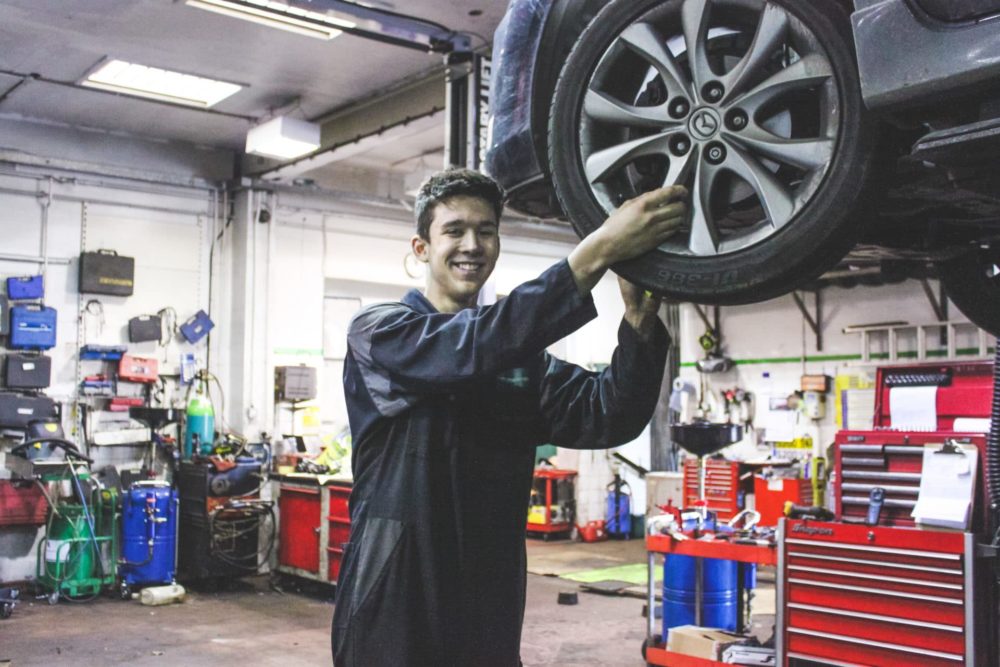 Motor Vehicle student Reiss Blackman working on a car wheel