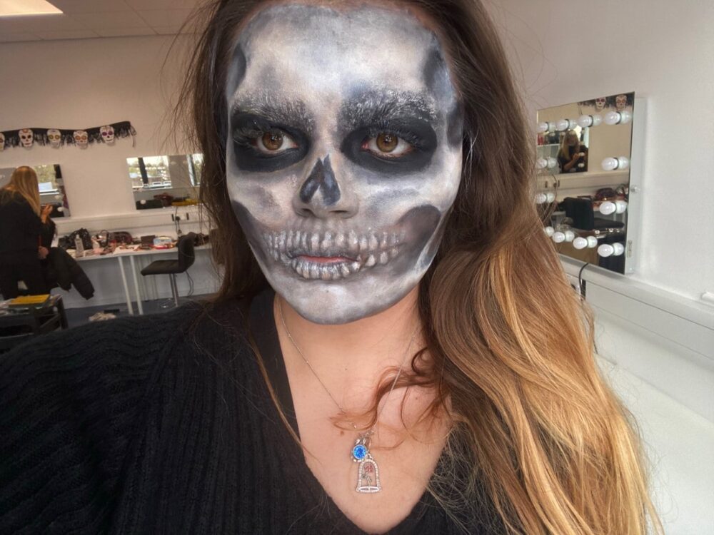 Student's face with grey skull make up on