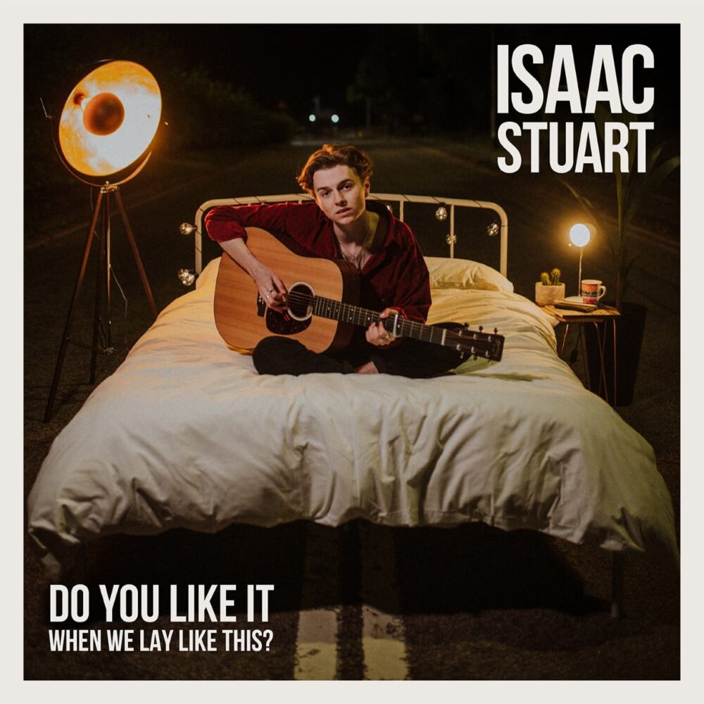 Student sat on bed playing guitar