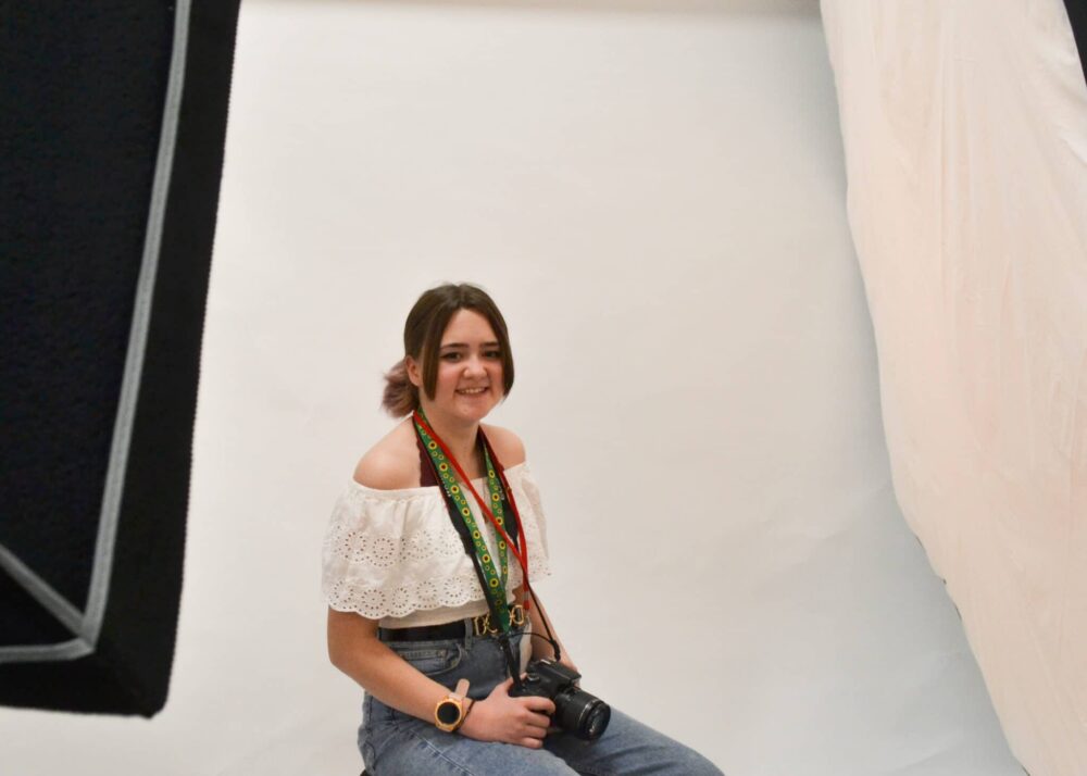 Photography student sitting with camera in hand