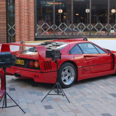 Cameras on tripod in front of Ferrari on photography course at Stratford