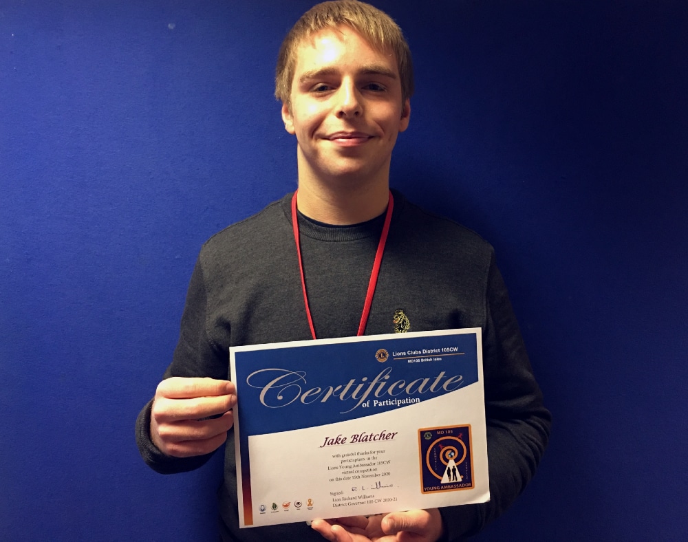 Student standing and holding certificate