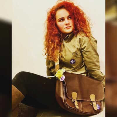 student sitting with bag around shoulder
