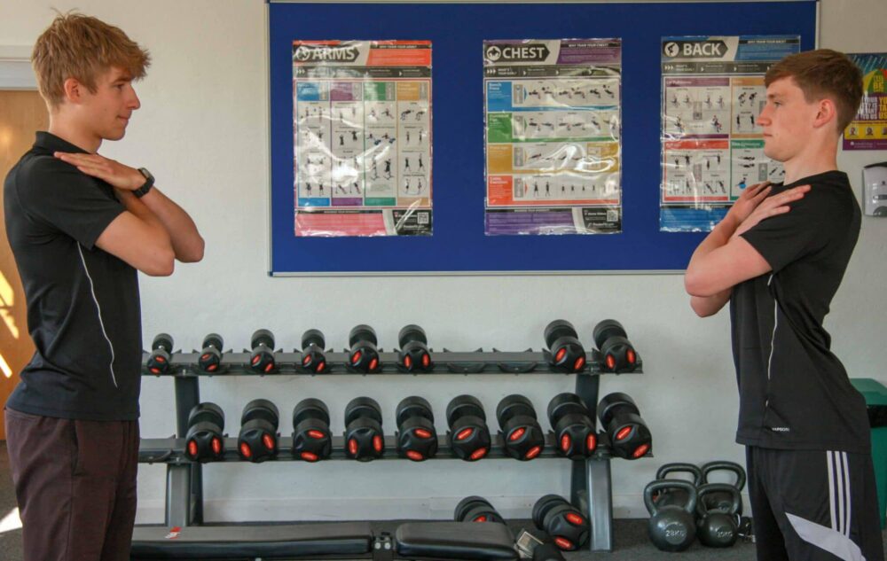 Students looking at each other with arms crossed on shoulder