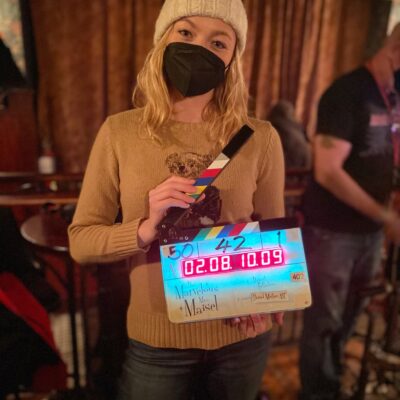 student holding clapper board with mask on
