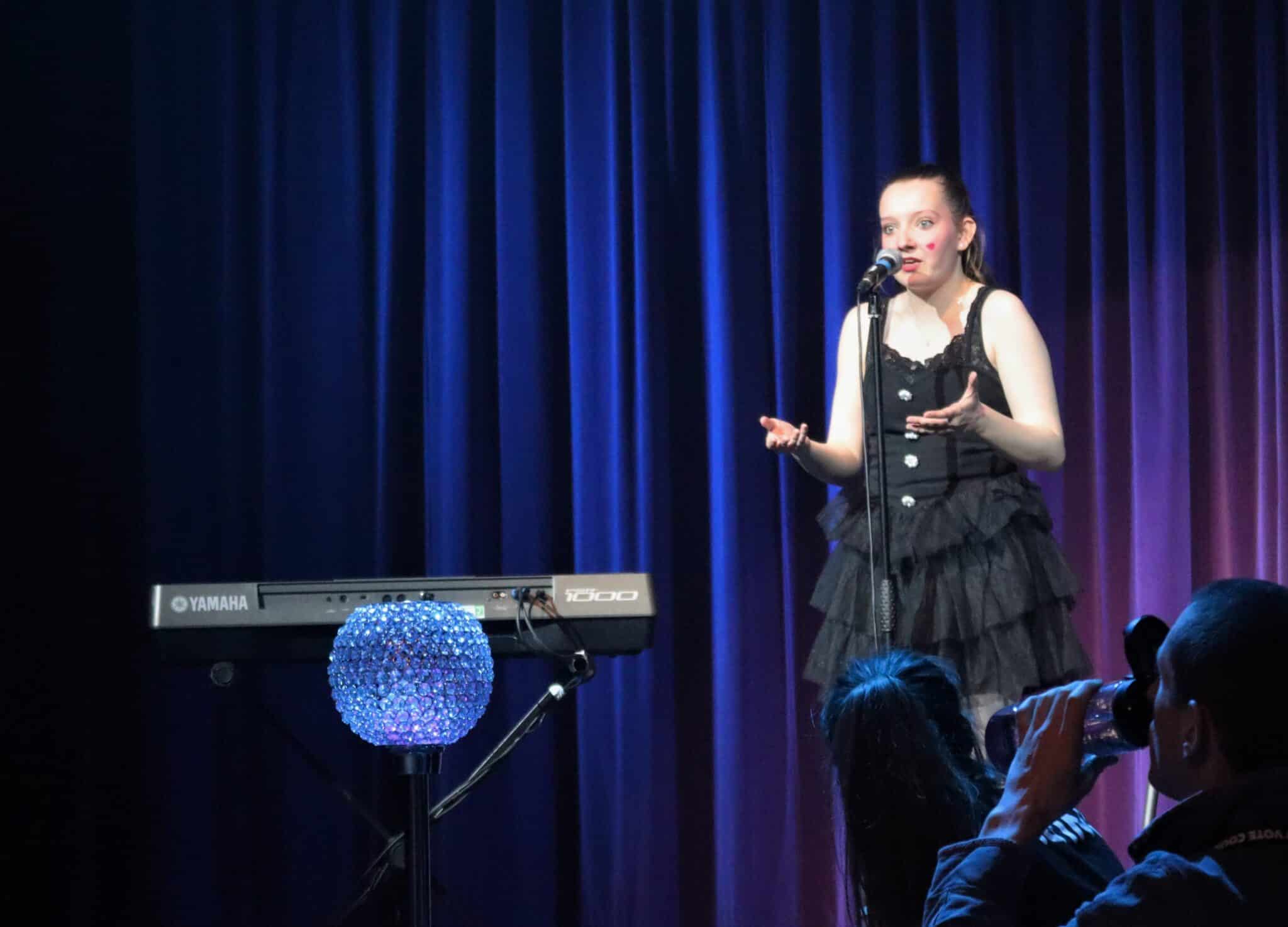 Student speaking in mic at cabaret
