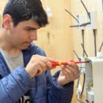 Stratford-upon-Avon College Electrical student practices installing fuse box.