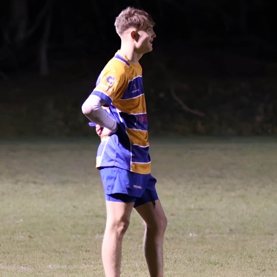 student standing in field with hands on hip - side shot