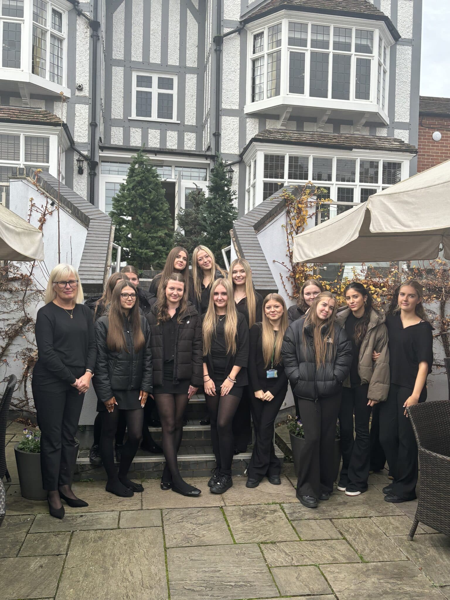 Group of Stratford College students stood outside entrance of hotel.