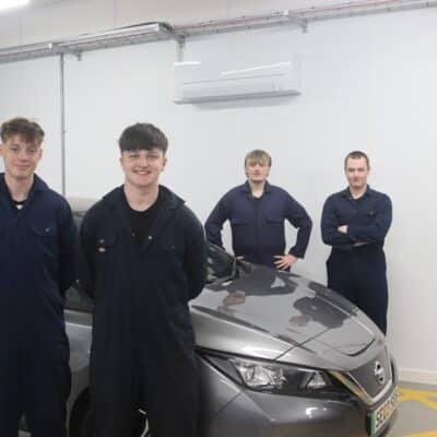 4 student stood in front of electric vehicle