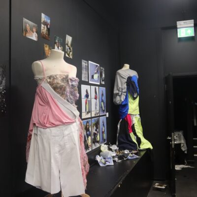 Fashion design mannequins with pink fabric drapped over it, photos in the back