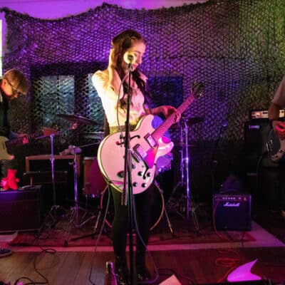 3 people with musical instruments stood on stage