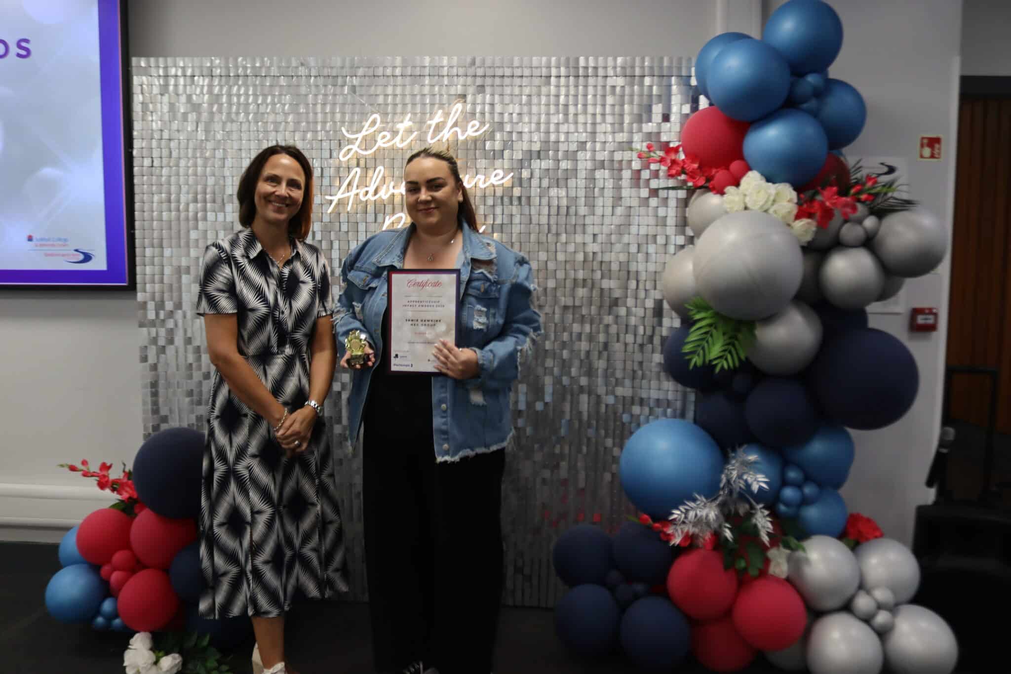 person receiving award next to balloons