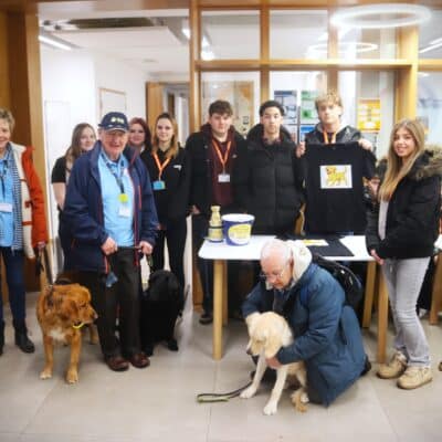 students staff and guide dogs surrounding table