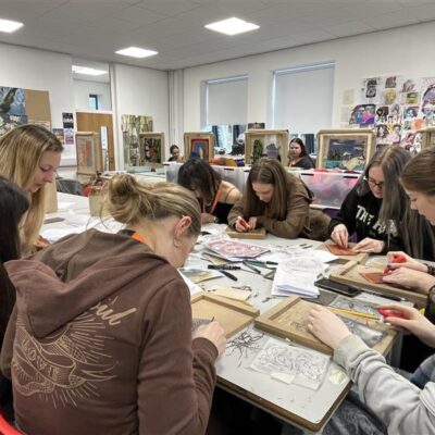 students around a table working on printing